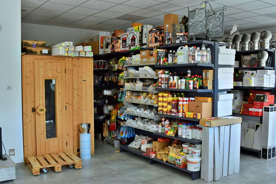 Asortyment wewnątrz budynku - półka pełna akcesoriów kominkowymi